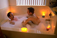 Gay men enjoy bubble bath together