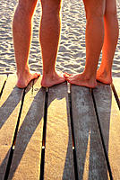 Couple´s feet together at beach boardwalk
