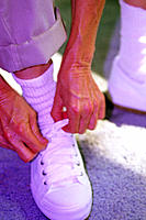 Senior woman tying shoelace