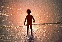 Naked child on waters edge