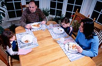 Family eating pizza at dinner table