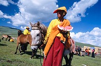 Monk with water melon. Litang Horse Festival. Sichuan. West China
