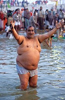 Fat man cheering in the Ganges river. Kumbh Mela festival. Allahabad, India.