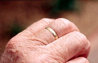 Wedding ring on aged hand.