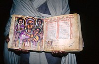 Priest shows an ancient Ethiopian Christian bible, handwritten in Amharic on goatskin pages. Asheton Maryam monastery, above Lalibela, Ethiopia