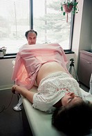 Doctor performs pelvic exam on pregnant female