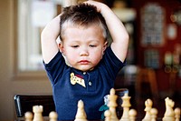 Young boy playing chess.