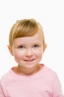 A three year old girl with blonde hair wearing  a pink top and hair pulled back,  looks into camera with a happy expression.