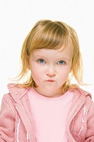 A three year old girl with blonde hair and blue eyes wearing a pink sweater and a pink top looks into camera with a concerned expression.