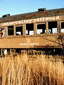 A decaying railroad car is photographed on a bright November day.