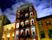 New York apartment buildings are captured at night with a blury, pastel effect.