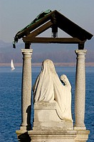 A statue of the Madonna seems to look for the safety of the sailors in the Lake Maggiore. Arona, Novara, Italy