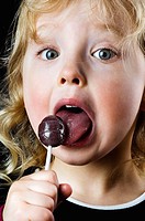 Little girl licking a sucker