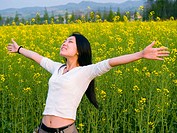 young good looking asian (chinese) girl enjoying the outdoors in a rape field