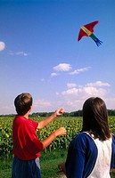 boy and girl flying a kite together