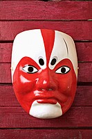 Asian mask on red wooden background