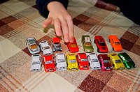 A little boy of 5 years playing with toy cars and cars of chocolate presented to him by his grandmother. While playing, sometimes eats one or two cars...