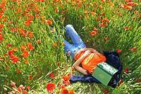 Woman lying on a poppies field
