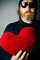 Man holding red heart pillow