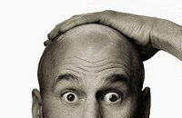 Bald caucasian man, 40-ish, with hand on top of head. Surprised look. Sepia