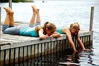 girl 13, girl 18 laying on dock together