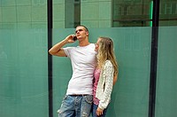 Attractive young urban couple, man talking on mobile phone