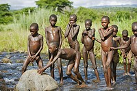 Surma children playing in the water of Kibisch river. Near Kibish. Ethiopia.