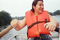 Latino woman rowing boat.