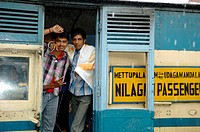 Loughing young indian men on board the Nilgiri Mountain Railway at Coonoor railway station in rain. India, Tamil Nadu, Coonoor 2005. - Info: The Nilgi...