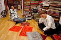 German female tourist negotiating prices for typical indian fabrics in a small boutique in the jewish part of Cochin (Kochi). Cochin, Kerala, India 20...