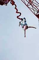 Woman bungee jumping from crane.