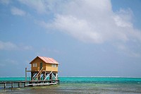 BELIZE San Pedro on Ambergris Caye   Colorful wooden building on stilts, end of dock, Caribbean waters