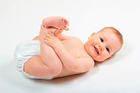 Baby lying on back, wearing nappies, playing with its feet, Studio, Oetwil am See, Zuerich, Switzerland