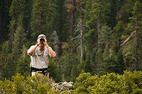 CALIFORNIA   South Lake Tahoe   Male day hiker use binoculars from overlook point