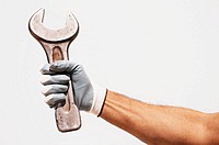 Worker arm holding a wrench.