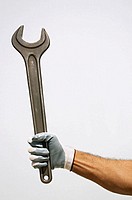 Worker arm holding a wrench.