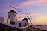 The windmills of Mykonos at dusk and sunset up on a hill at Hora or Mykonos town, Greece.