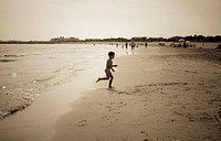 Boy playing in Pinedo beach. Valencia. Spain.