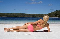Woman lying on beach, seen from behind. Fraser Island, Australia