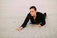 Desperate woman, concept, lost. Woman on beach sand dressed in executive outfit