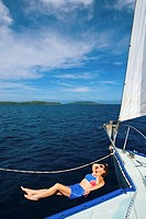 Holiday maker relaxing on sailing charter vessel, Vava´u, Kingdom of Tonga, South Pacific.