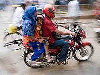 Travelers crowd onto motorcycles on the road in Bangalore, Karnataka, India