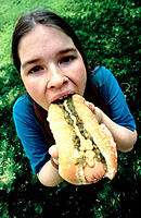 Girl eating hotdog.