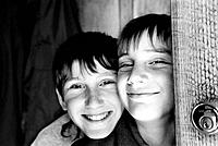 Boys smiling in doorway at home -black and white film-