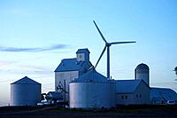 Modern grain handling facility with wind generator towering over it on Iowa farmstead near Williams, Iowa, USA  Photo shows grain elevator tall struct...
