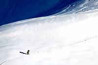 Lone skier near the Aiguille du Midi cable car station, Les Bossons, Chamonix Mont Blanc, Rhone-Alpes, France