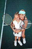 Mother and daughter posing with tennis rackets