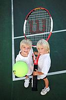Kids with an oversized tennis racket and ball