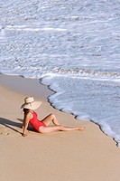 Woman sitting on beach, Maui, Hawaii, USA