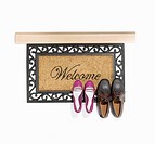 Welcome mat with two pairs of shoes.